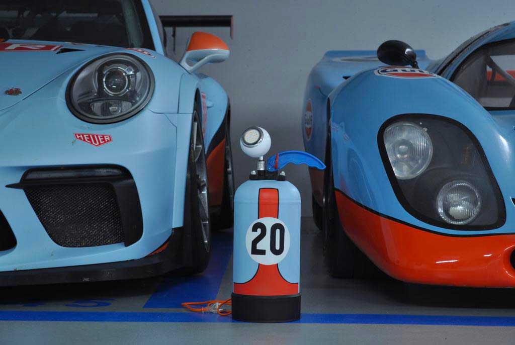 Lamp extinguisher vintage gulf blue and orange number 20 in between Porsches JLR Concept