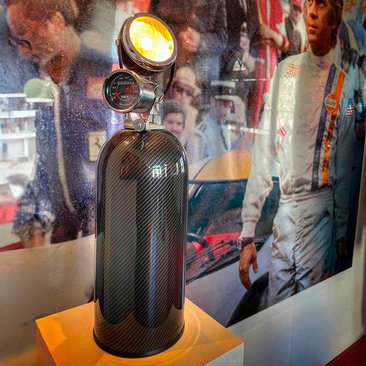 Full carbon vintage lamp extinguisher with pressure gauge and headlamp next to Steeve McQueen Poster JLR Concept